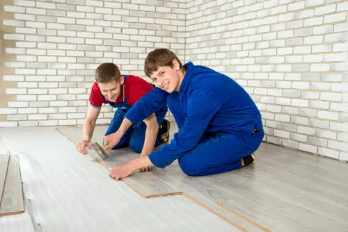 Deux hommes posent un parquet